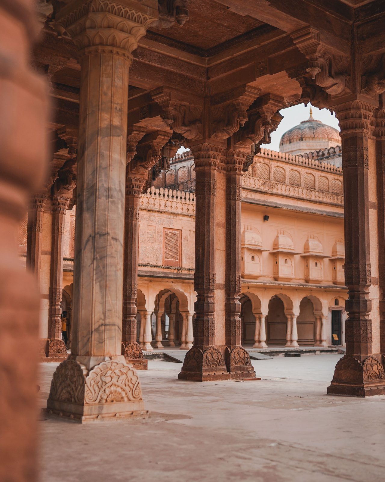 Beautiful pillars and arches of Jaipur palace courtyard showcasing intricate Indian architecture.