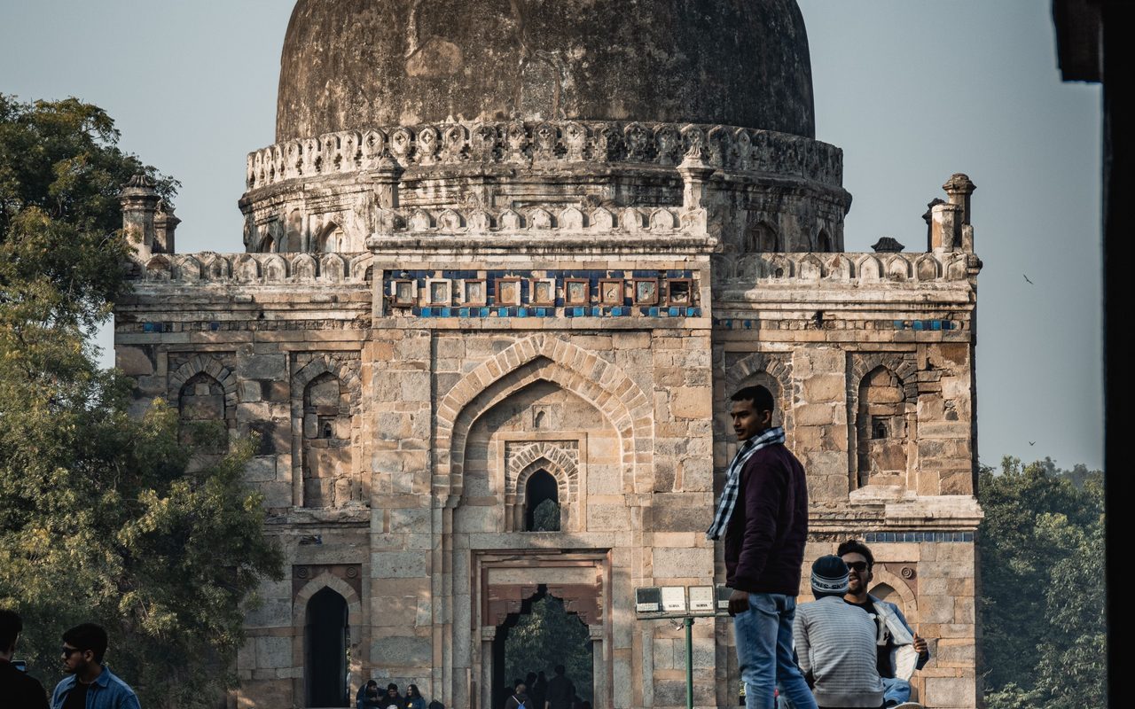 A scenic view of the historic tomb at Lodhi Garden, New Delhi with visitors exploring the site.
