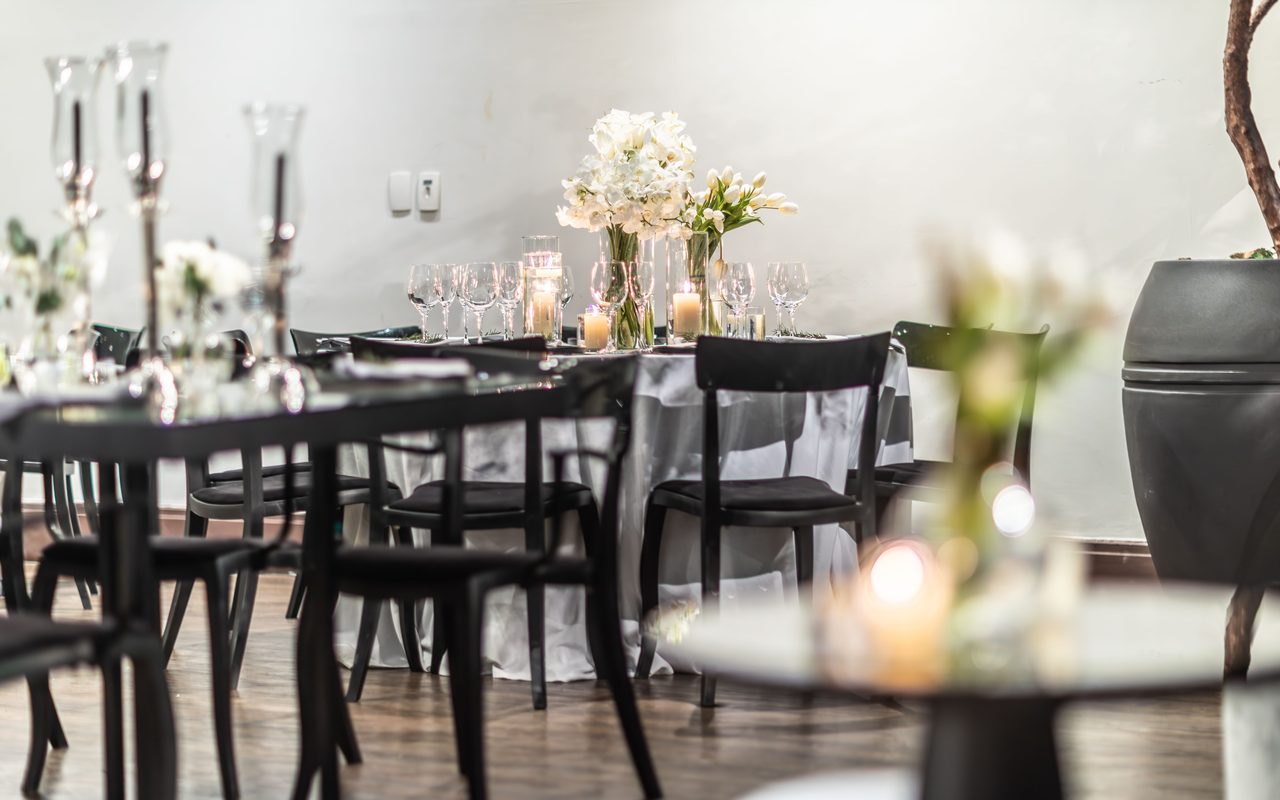 A beautifully arranged wedding reception table featuring candles and flowers, creating a warm and intimate atmosphere.
