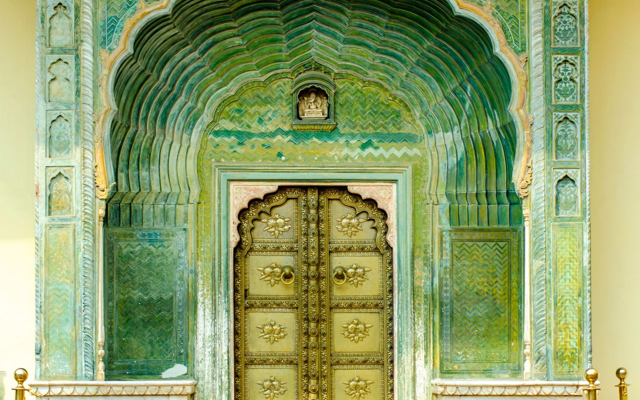 the artistic green doorway with ornate carvings at the City Palace in Jaipur, India.