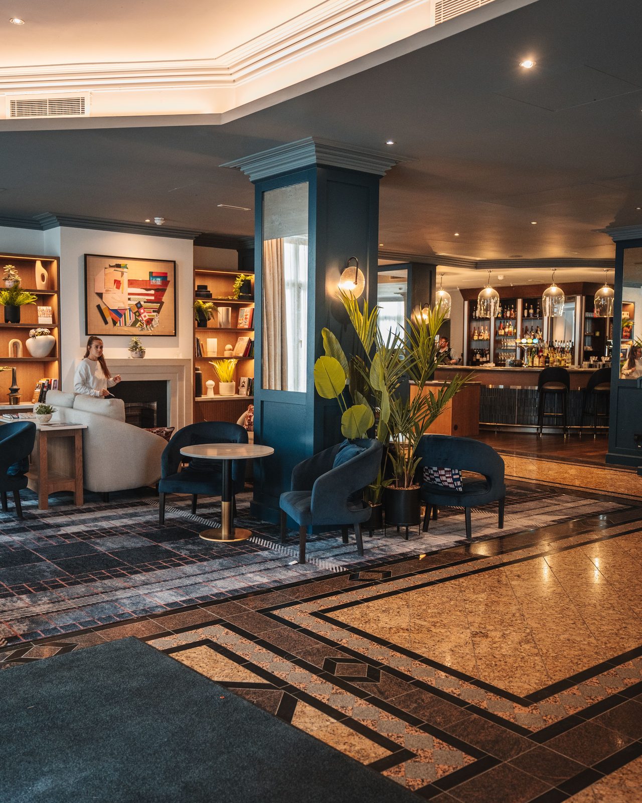 Modern hotel lounge featuring elegant seating, art, and warm lighting.