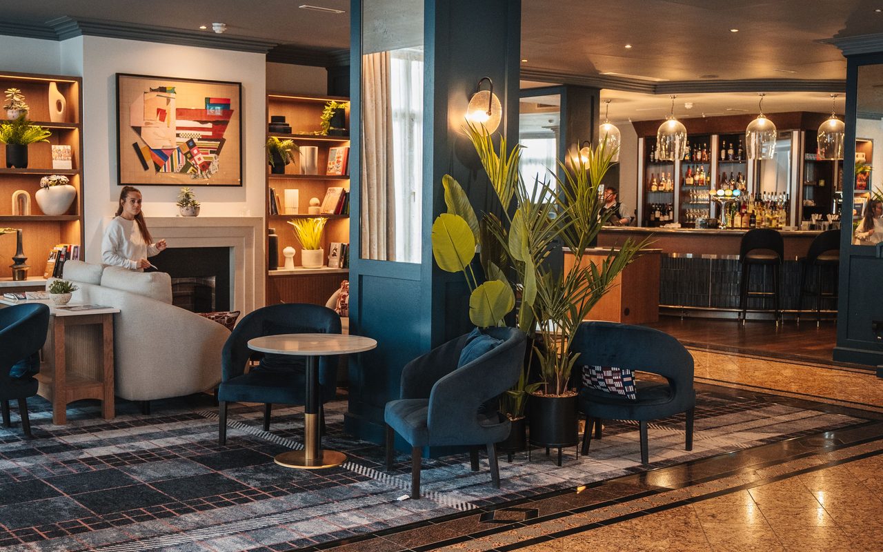 Modern hotel lounge featuring elegant seating, art, and warm lighting.