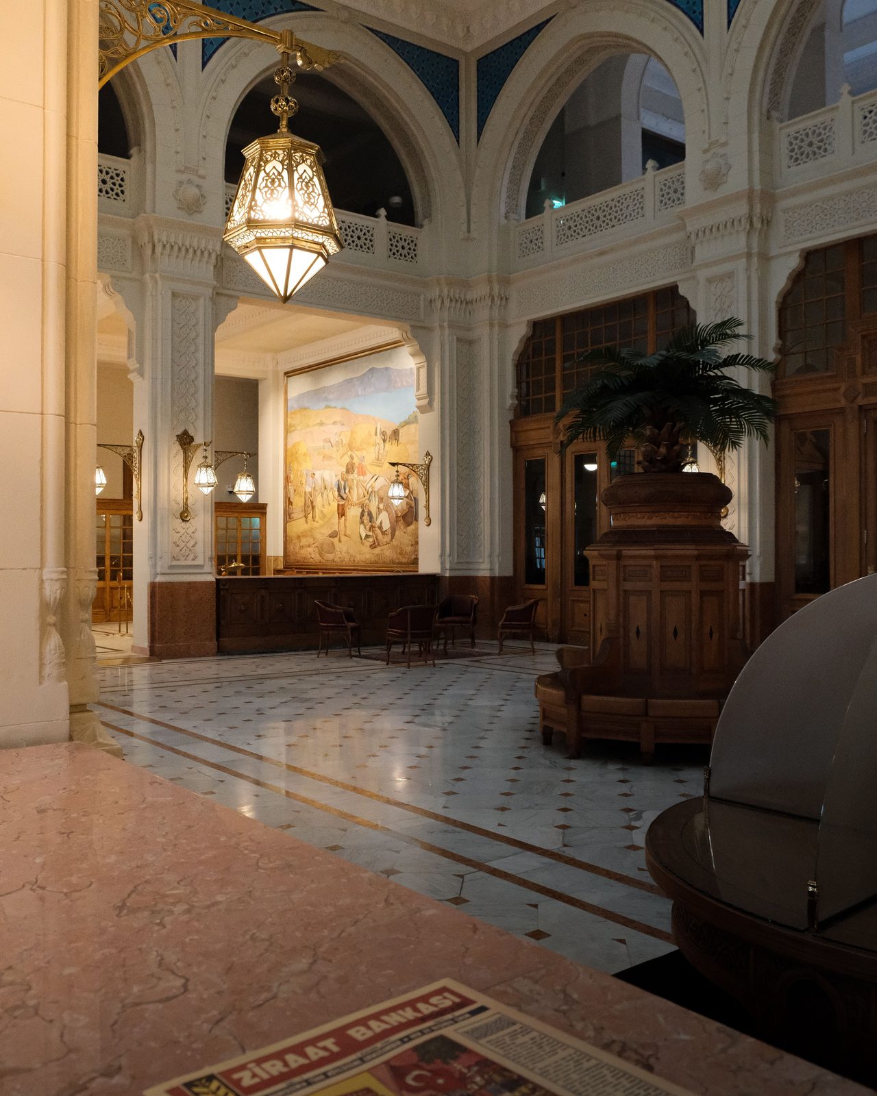 Elegant historic lobby with ornate architecture and warm lighting in an empty space.
