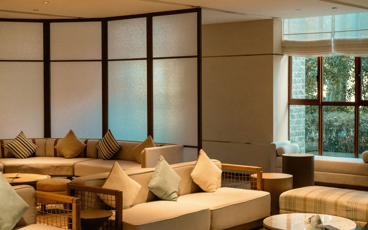 Stylish lounge seating area with comfortable sofas and natural lighting, perfect for relaxation.