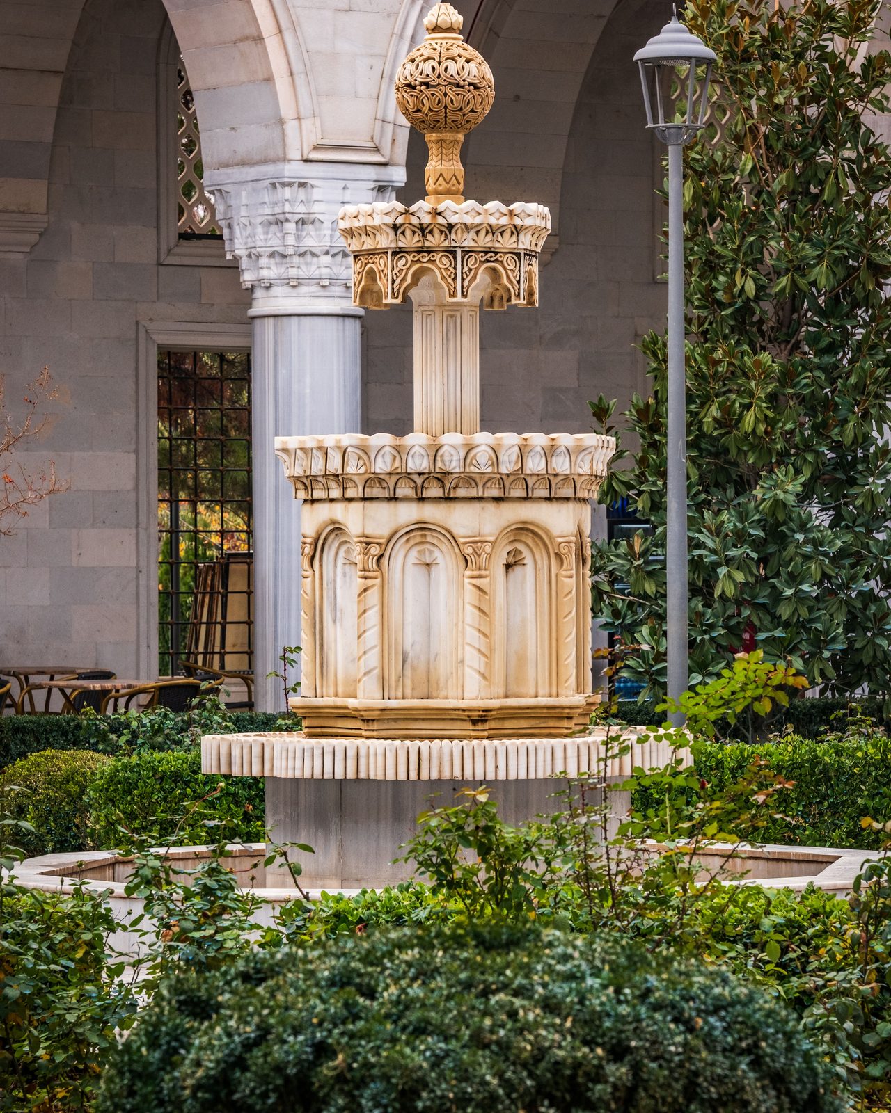 Beautiful ornate stone fountain in a historical courtyard garden setting.