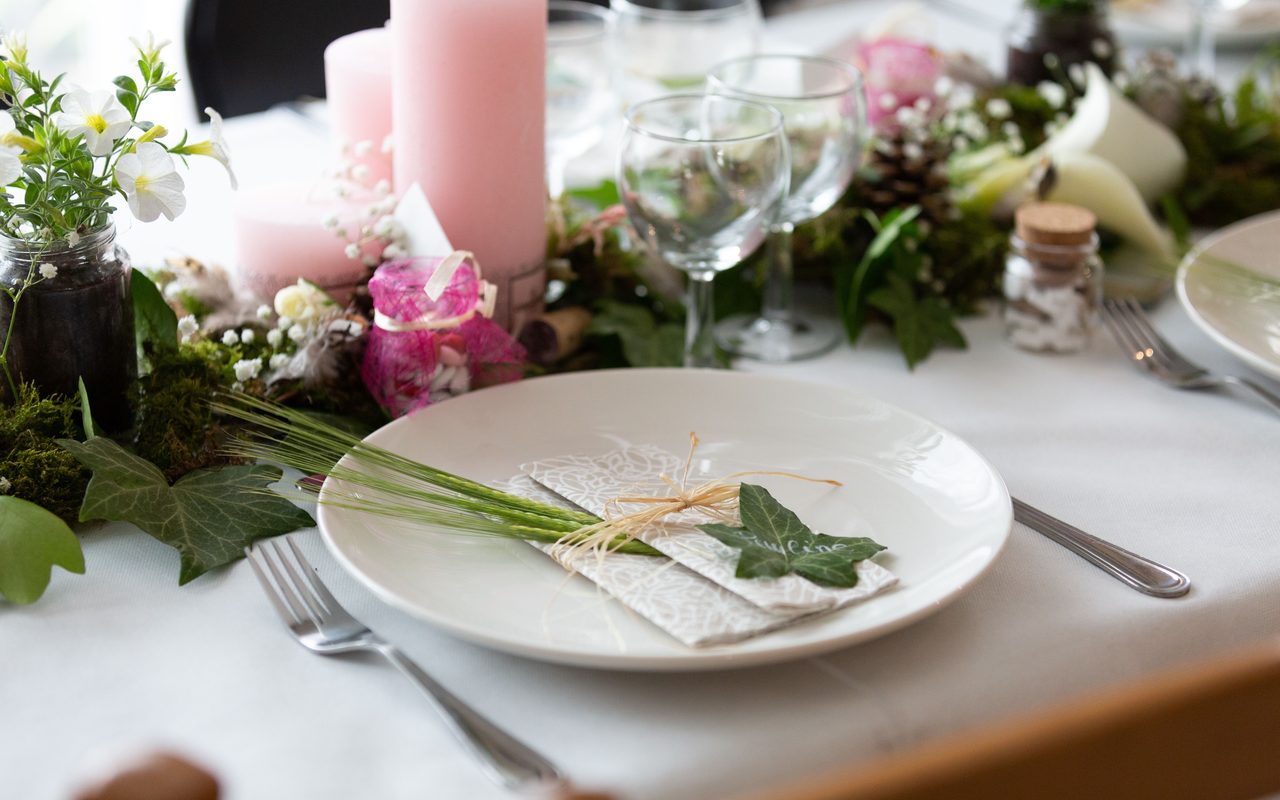 Beautifully arranged wedding table setting with floral centerpiece and candles for an elegant reception.