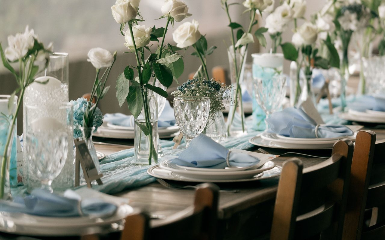 Charming table setup with white roses and glassware, perfect for weddings or celebrations.