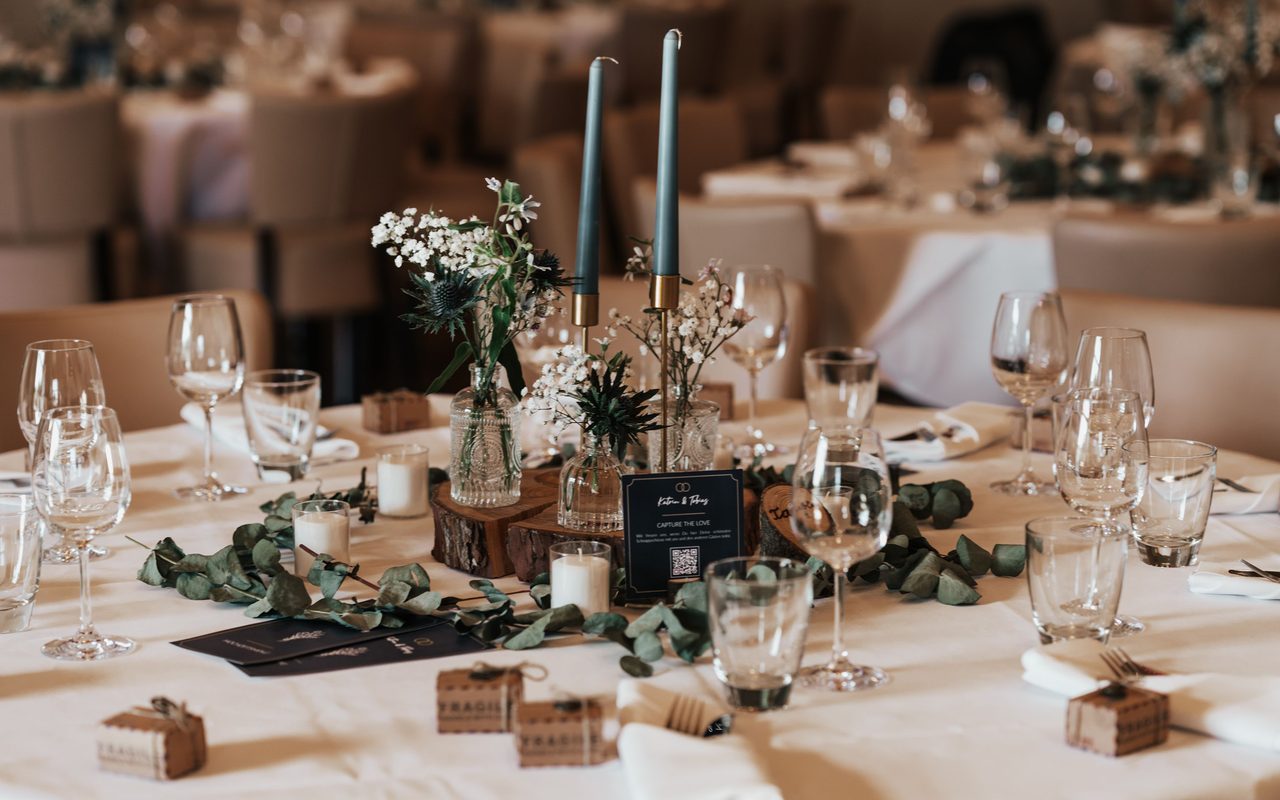 A beautifully decorated wedding reception table with candles and floral arrangements.
