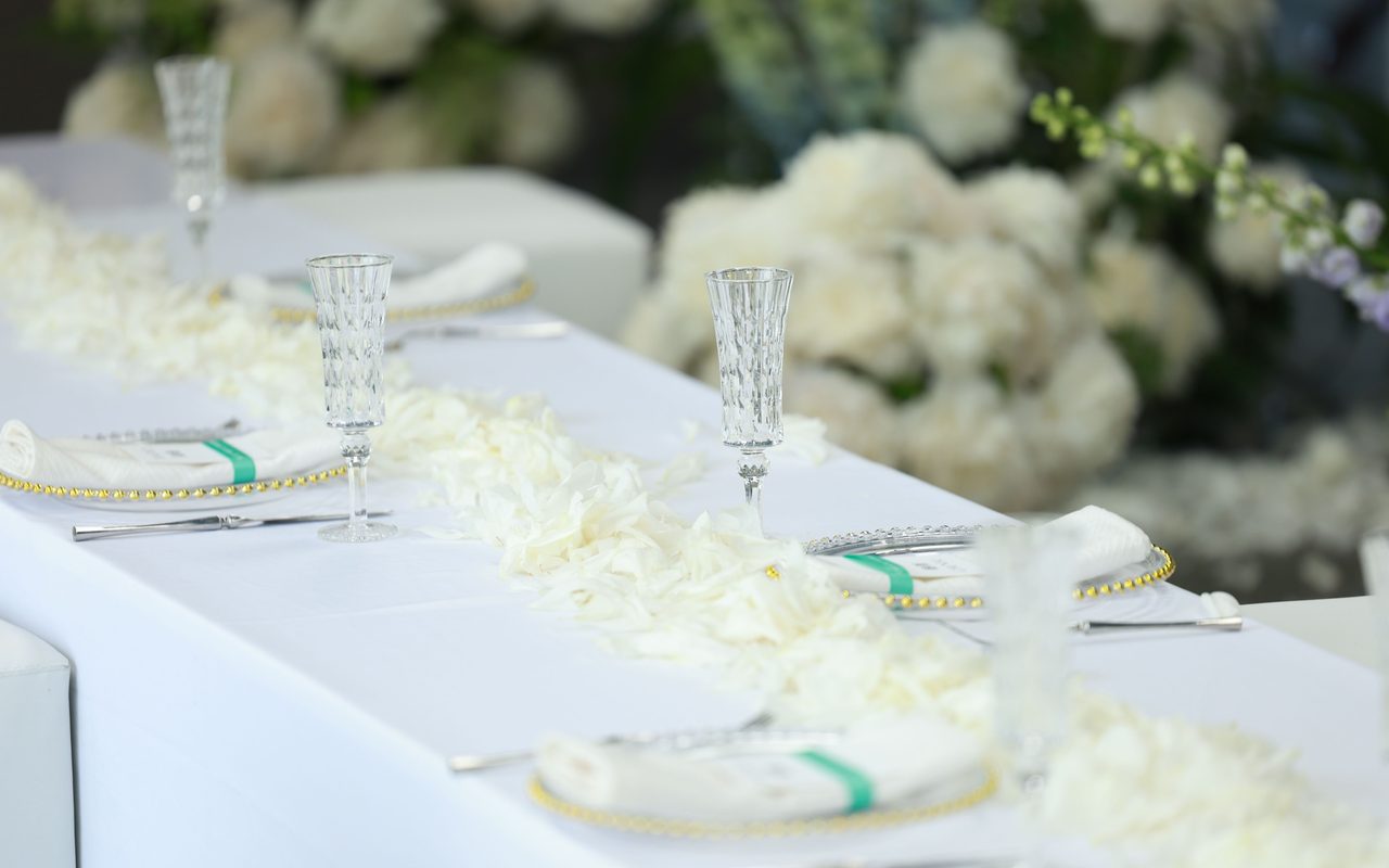 Beautiful wedding table setup with white roses and crystal glasses, perfect for elegant celebrations.