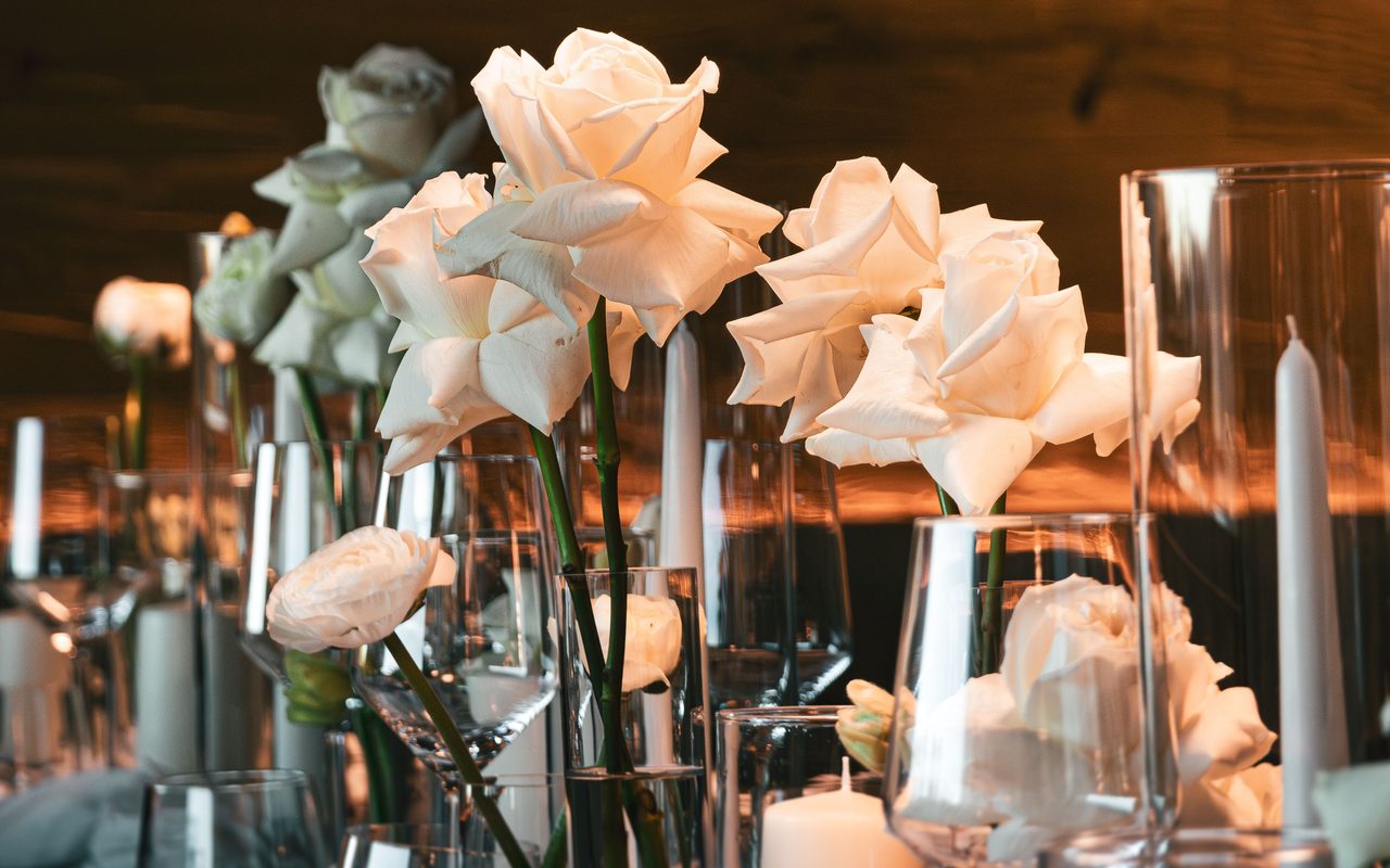 A stunning table setup featuring white roses in a sophisticated wedding decor.