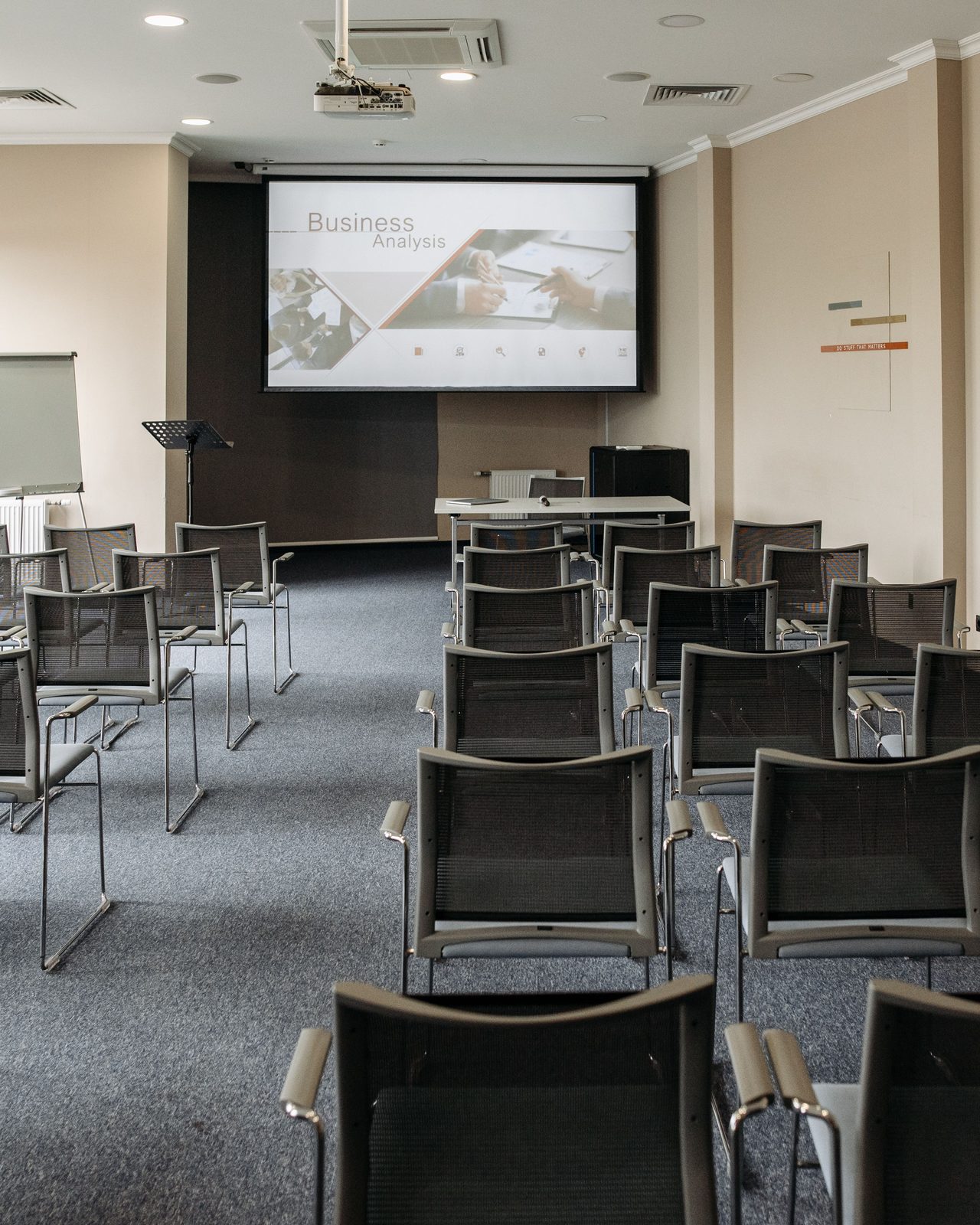 Empty conference room with chairs and a presentation screen setup for business meetings.