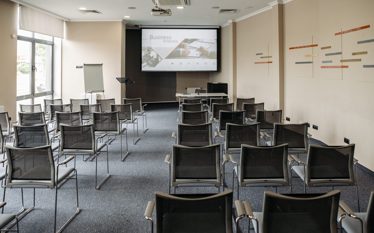 Empty conference room with chairs and a presentation screen setup for business meetings.