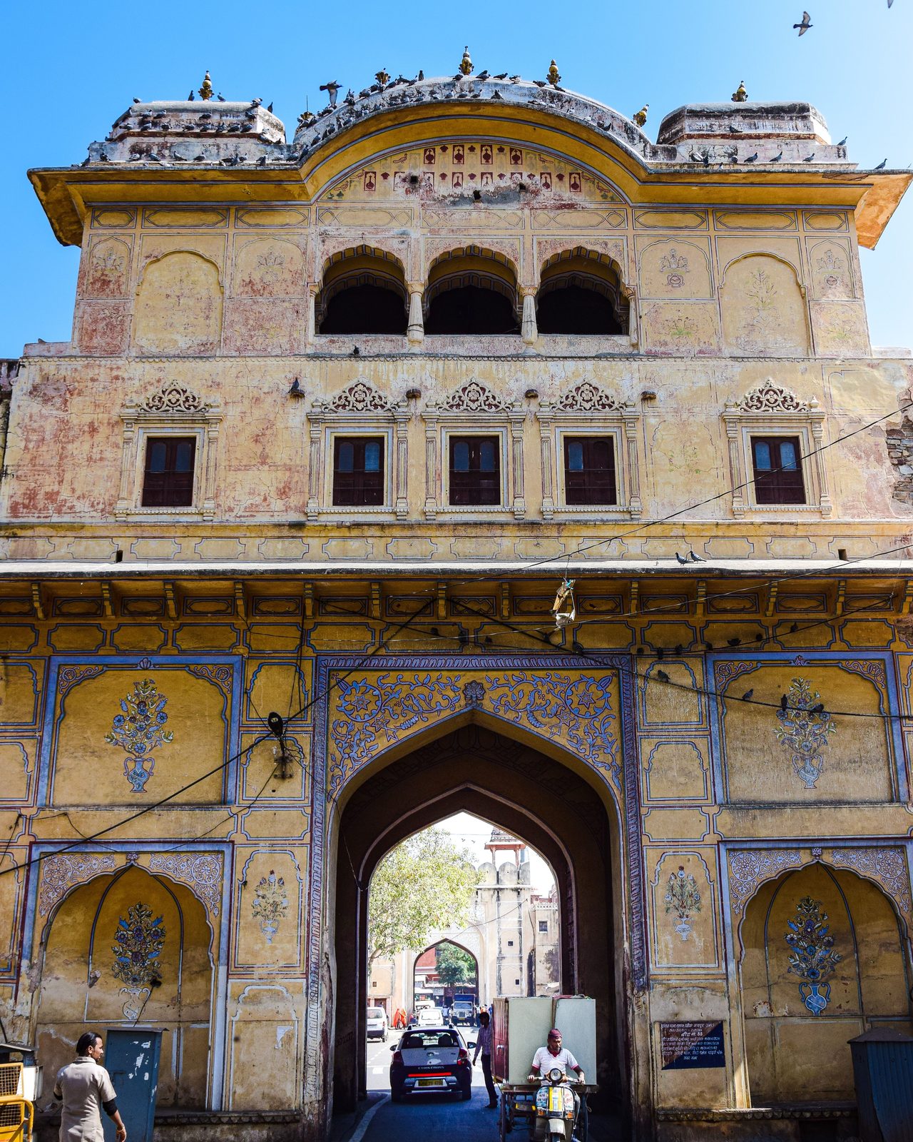 Historic entrance gate of City Palace, Jaipur with architectural details under a clear blue sky.