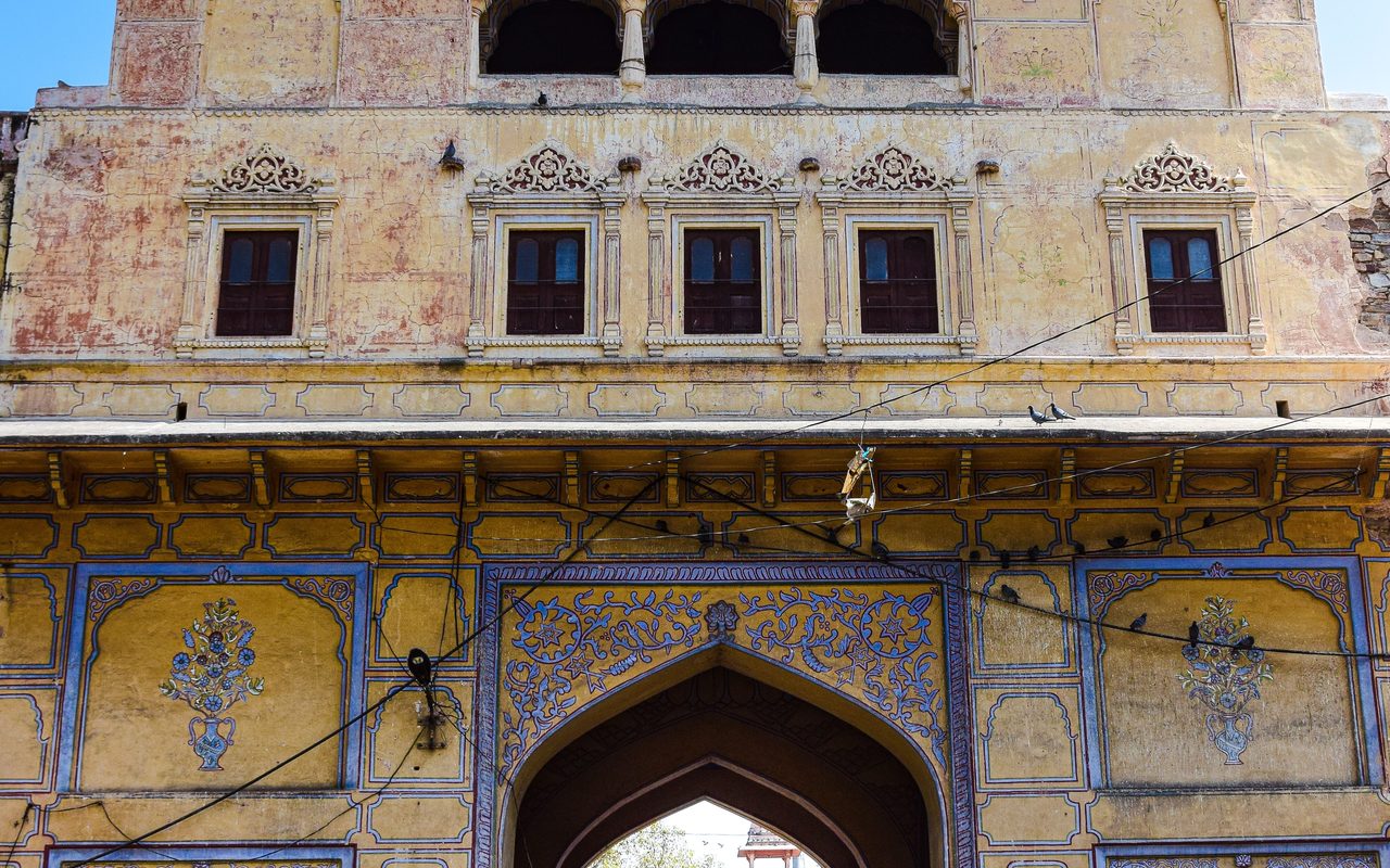 Historic entrance gate of City Palace, Jaipur with architectural details under a clear blue sky.