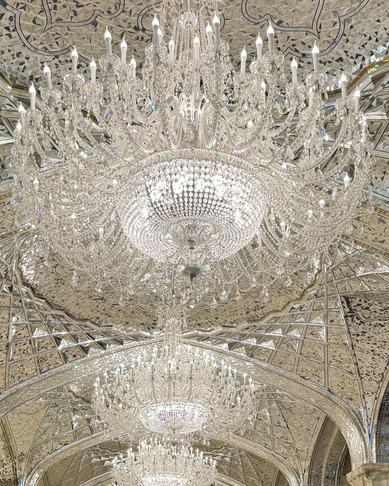 Crystal chandeliers and intricate heritage vaults viewed from below