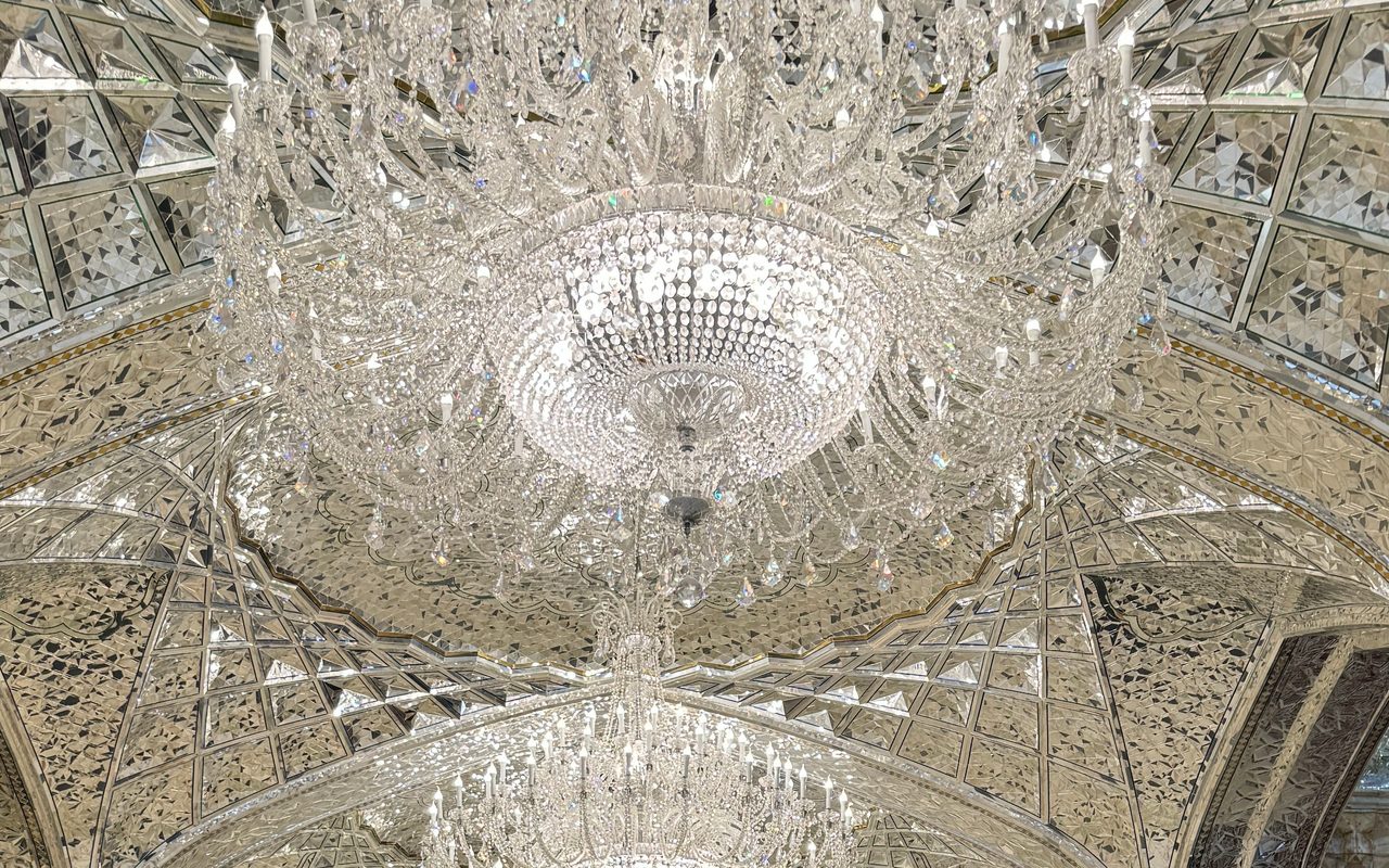 Crystal chandeliers and intricate heritage vaults viewed from below