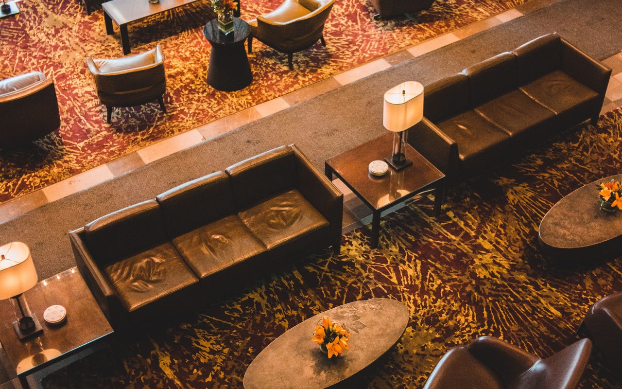Modern hotel lobby with luxurious seating, contemporary design, and warm lighting from a high angle view.