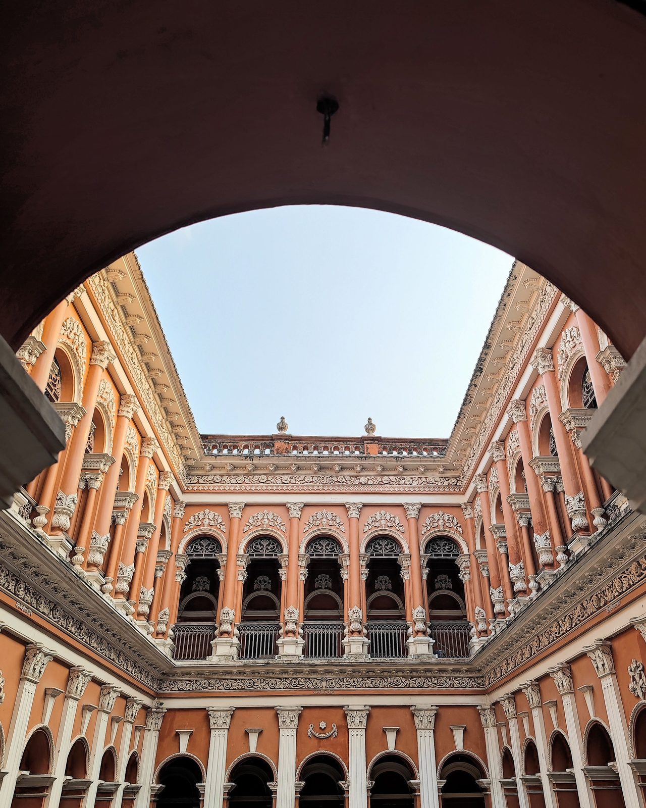 a historic pink palace courtyard with ornate arches and balconies.