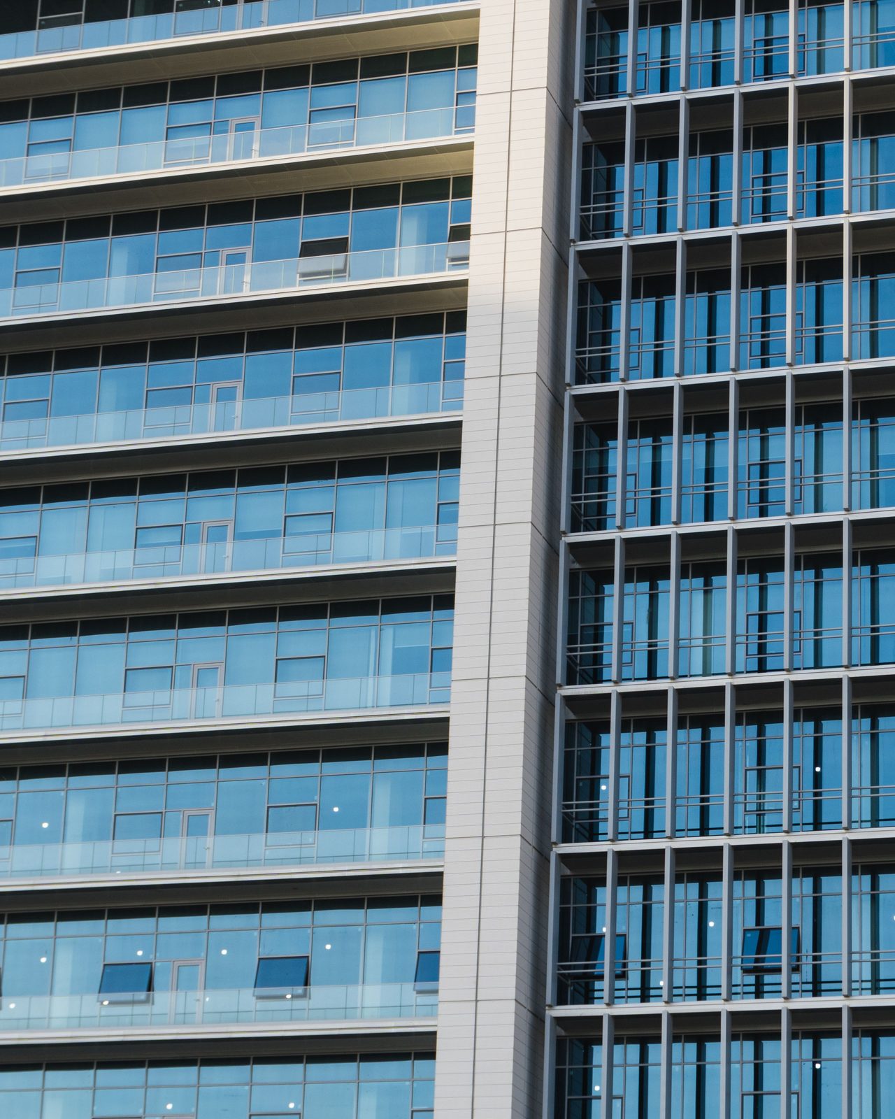 Detailed view of a modern highrise office building with glass windows and reflections.
