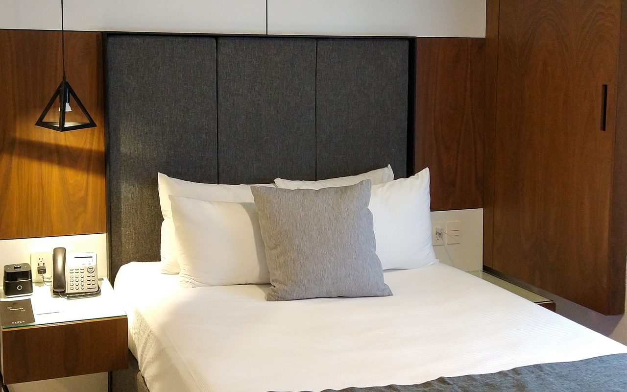 Elegant hotel room interior in Cancún with modern design and cozy bedding.