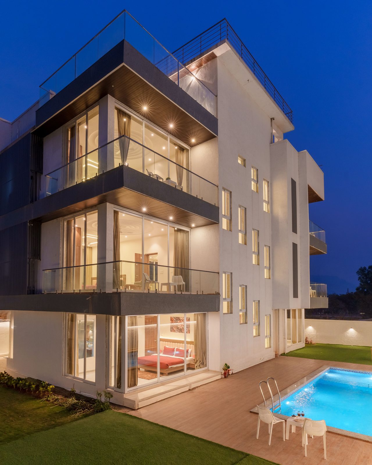 Elegant modern villa with pool, captured at twilight, showcasing contemporary architecture.