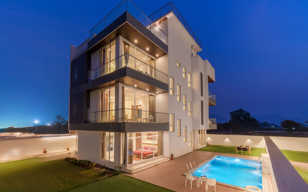 Elegant modern villa with pool, captured at twilight, showcasing contemporary architecture.