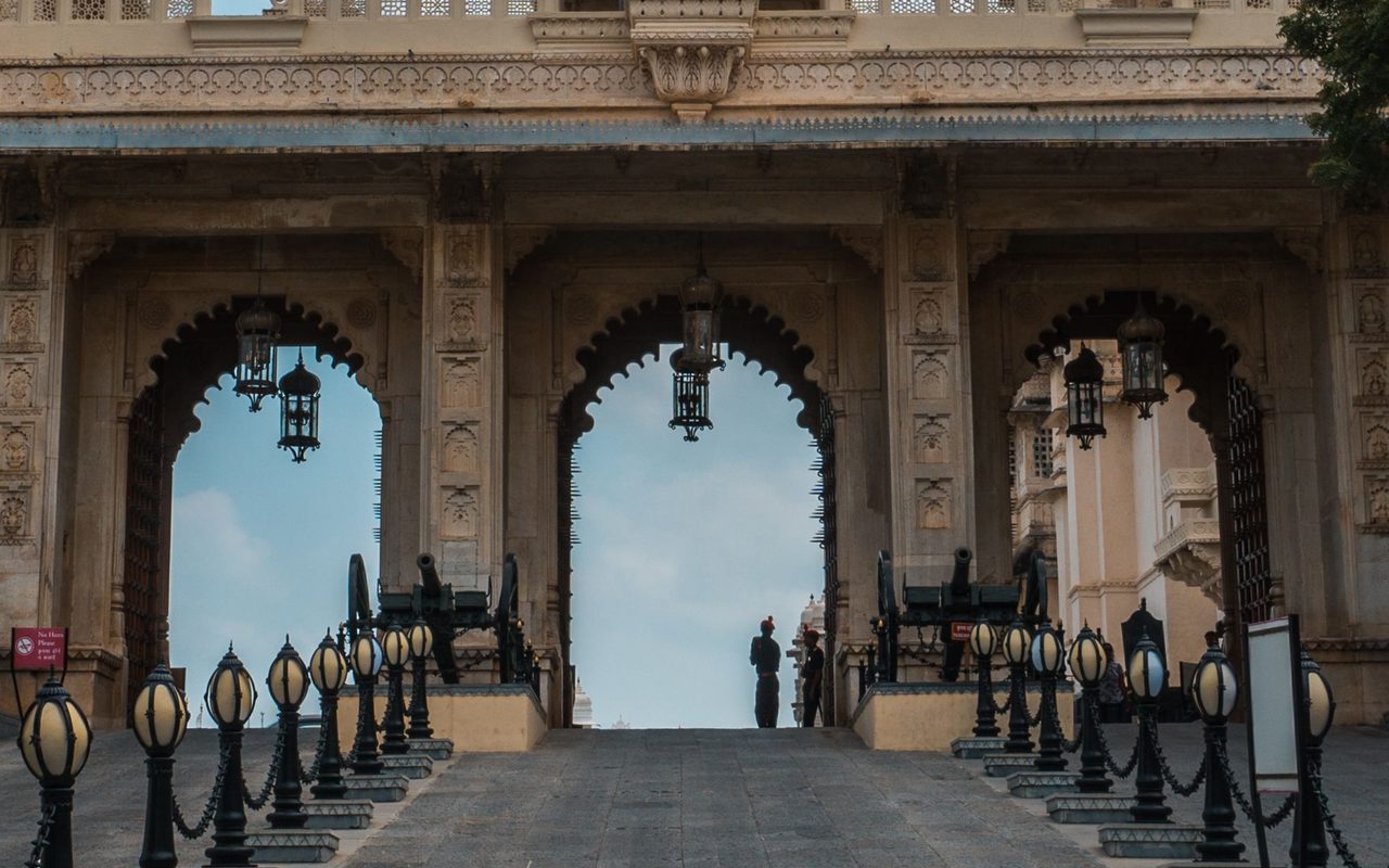View of a historic archway entrance in Udaipur, India, showcasing intricate architectural design.