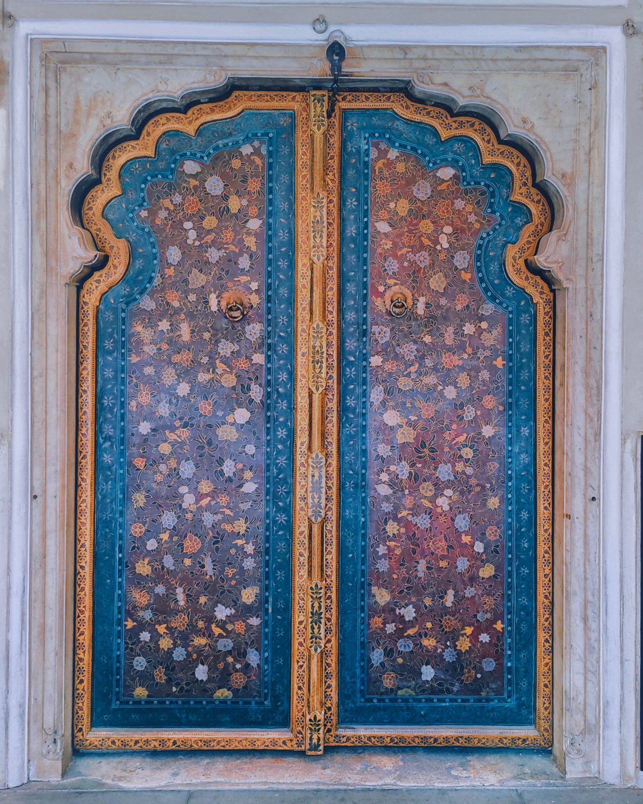 Intricately carved and painted wooden door with traditional Indian motifs in vibrant colors.