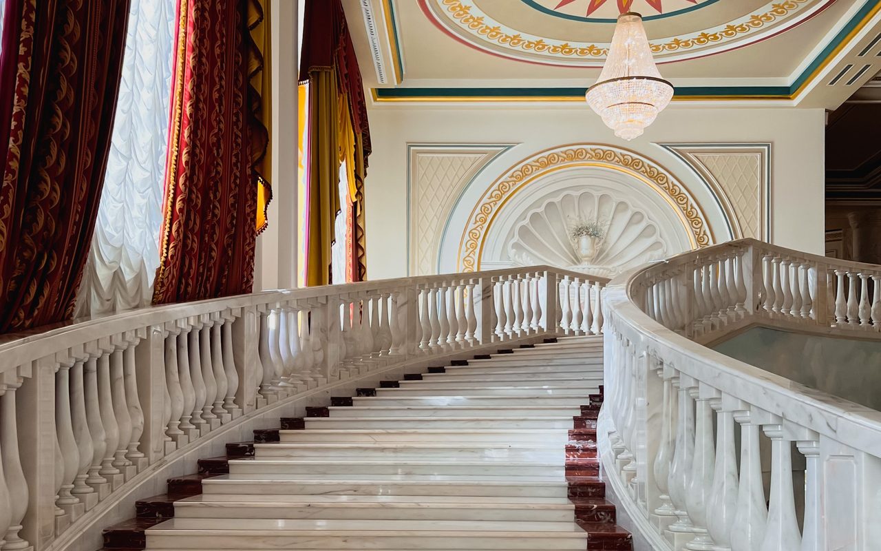 Luxurious interior staircase with marble steps and opulent ceiling design, exuding elegance and grandeur.