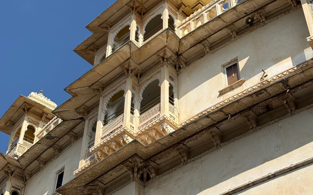 Historic City Palace in Udaipur showcasing Rajasthani architecture under a clear blue sky.