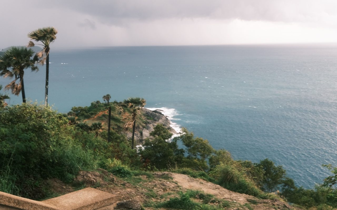 the stunning coastline of Phuket, Thailand with lush greenery and ocean views.