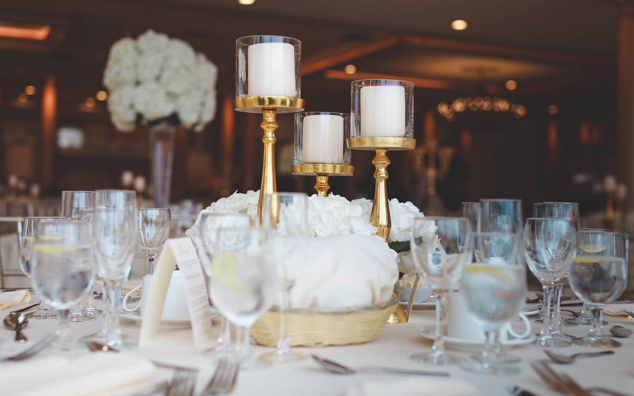 Luxurious table setting featuring candles and white roses, ideal for a banquet or fine dining experience.