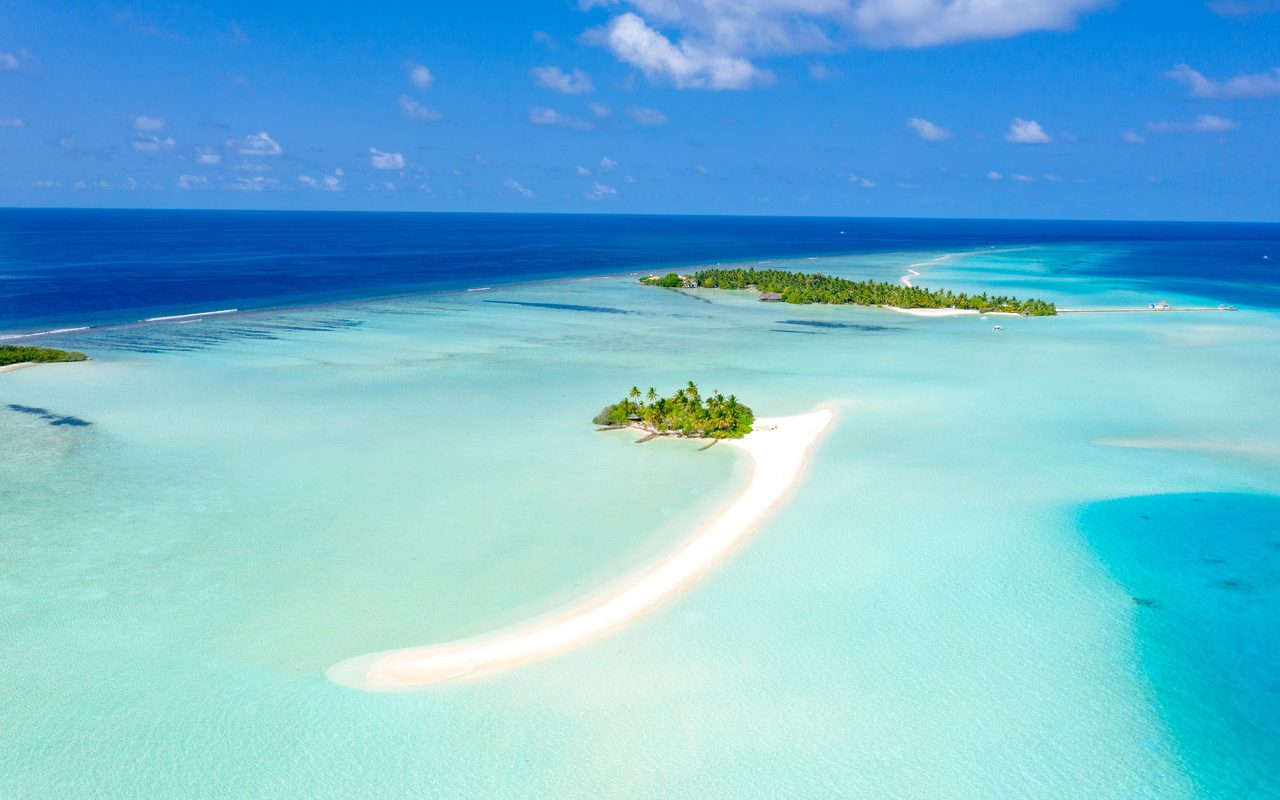 A breathtaking aerial shot of a tropical island with clear turquoise waters in the Maldives.