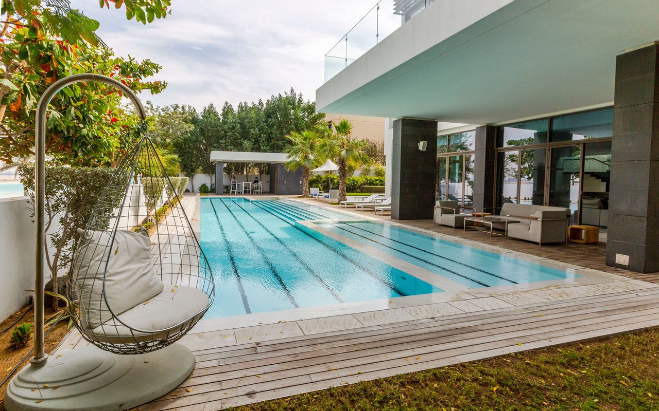 a modern luxury villa featuring a sleek swimming pool and spacious terrace in Dubai.