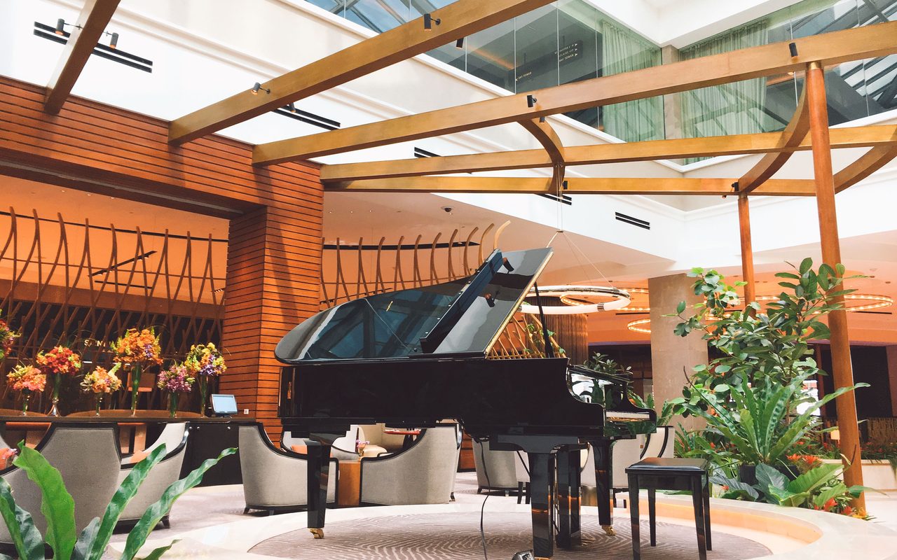 An elegant hotel lobby in Manila featuring a grand piano and modern interior design elements.