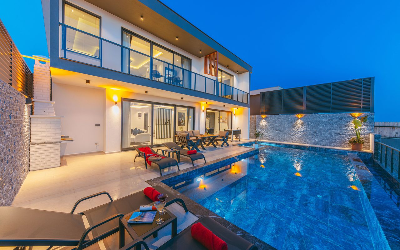 A tranquil evening at a modern luxury villa with a stunning poolside ambiance, perfect for relaxation and vacation.