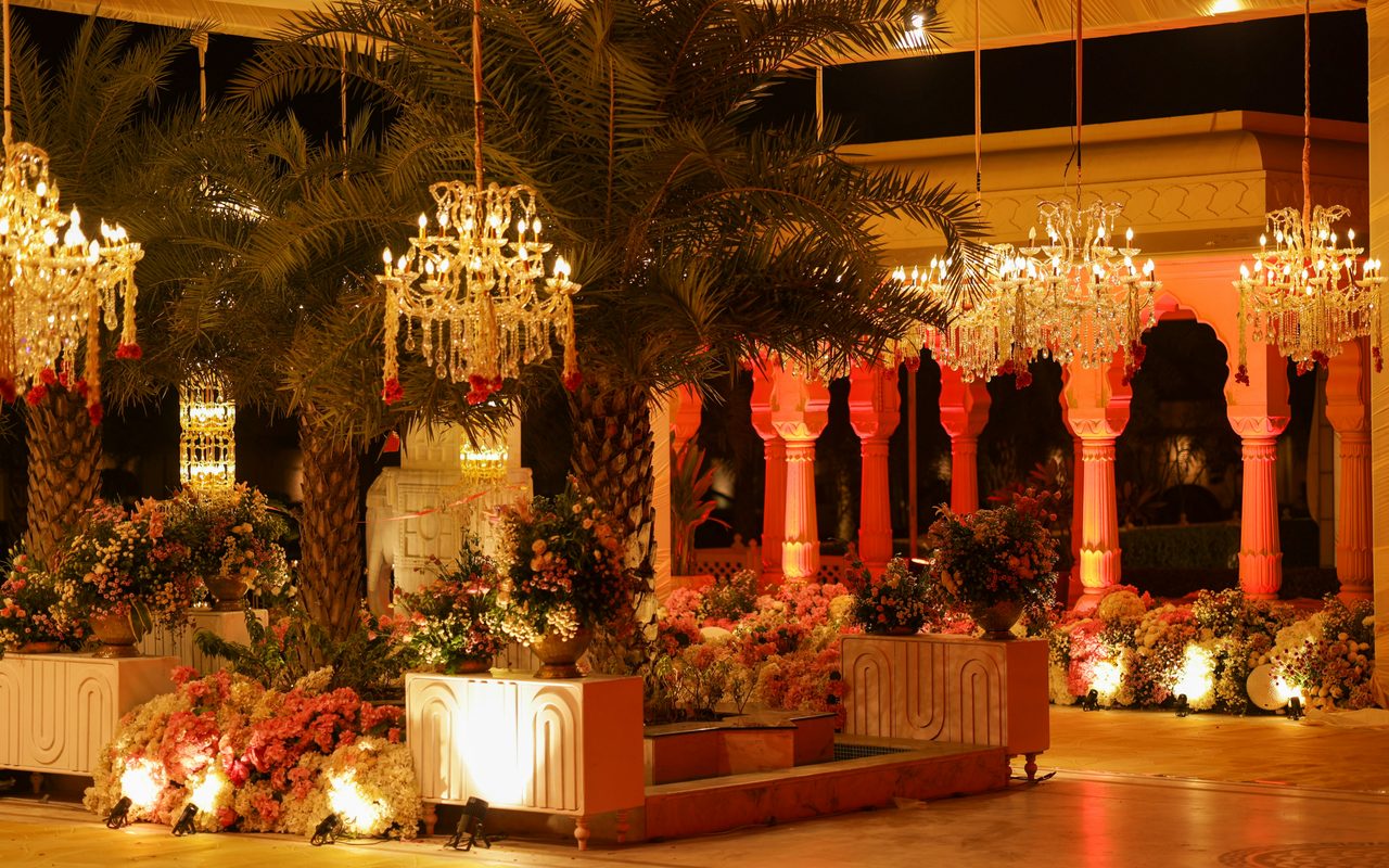 Floral wedding installation with crystal chandeliers in warm evening light