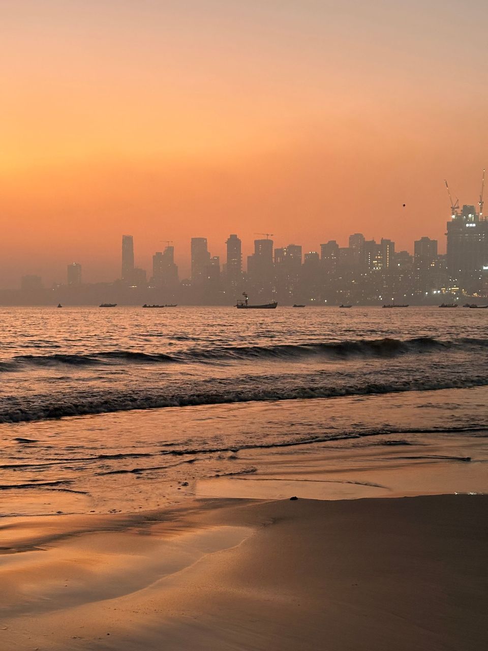 Sunset over the sea and distant skyline in Mumbai