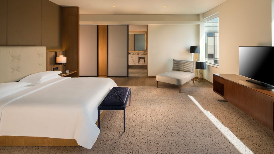 Spacious suite bedroom with a lounge chair