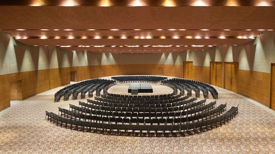 Event hall with circular rows of chairs around a central stage