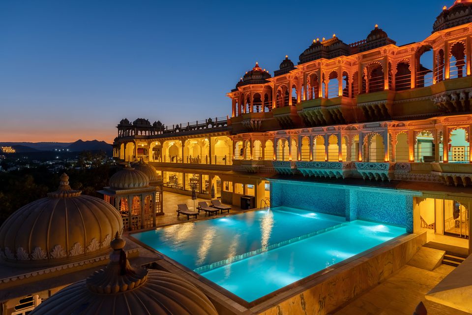 Illuminated palace and rooftop pool at dusk