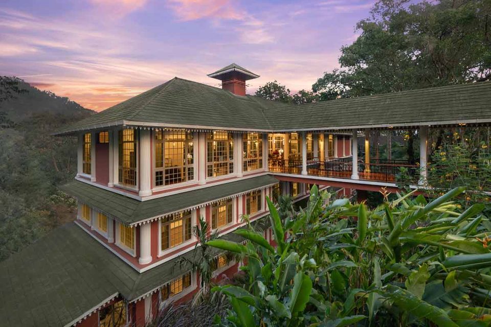 Lit resort building among trees at dusk