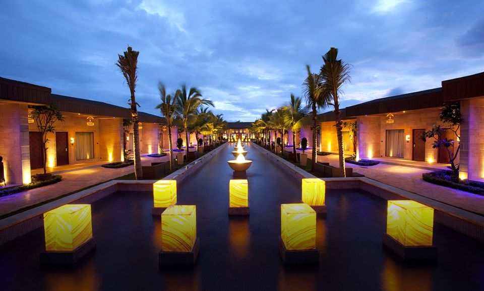 Palm-lined water feature illuminated at dusk