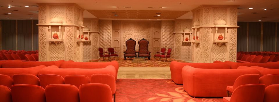 Ceremonial hall with carved arches and red seating