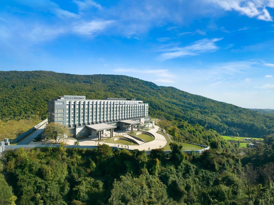 Aerial view of the hotel surrounded by forested hills