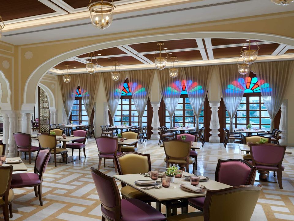 Restaurant tables beneath arches and coloured glass windows