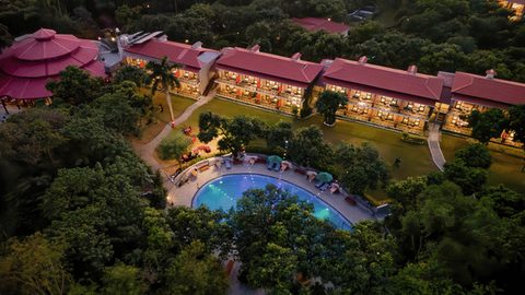 Aerial view of the resort with red-roofed buildings, lawns and swimming pool at Infinity Resorts Corbett