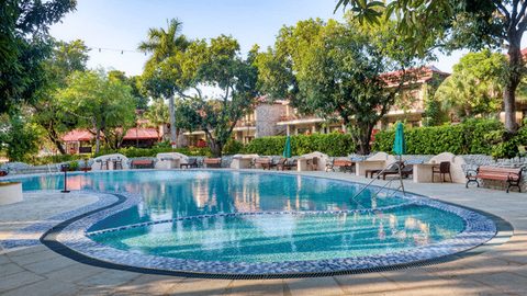 Outdoor swimming pool with lounge chairs at Infinity Resorts Corbett