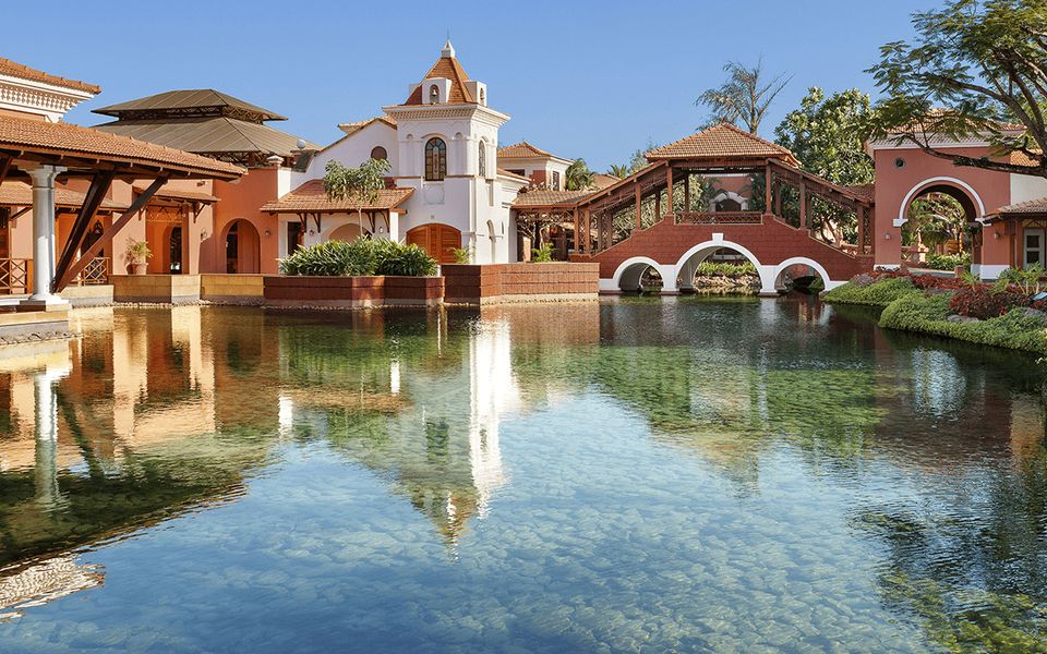 Arched resort buildings reflected in water