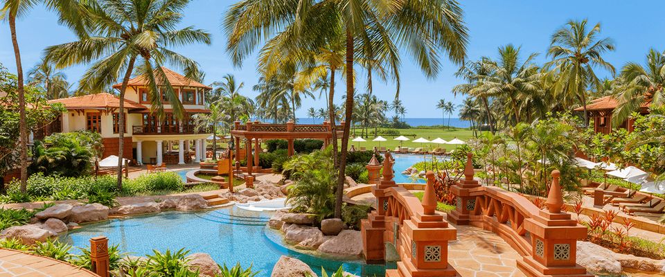 Palm-lined swimming pools and garden bridges